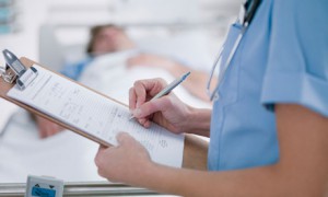 Nurse tending patient in intensive care.